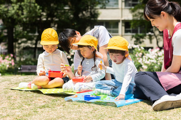 公園でお弁当を食べる園児
