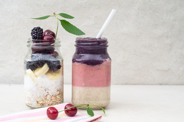 Three-layer smoothie of cherry, banana and blackberry with yogurt and oatmeal