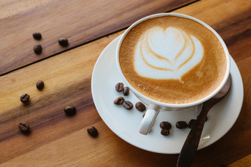 Coffee cup and coffee beans on wooden table