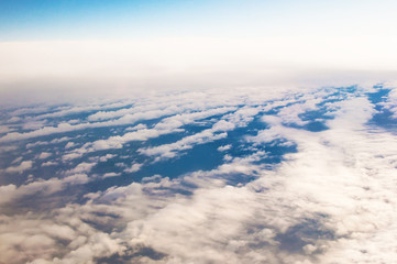 Dreamlike view of many white fluffy clouds in warm light