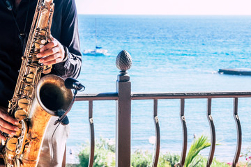 closeup of music artist saxophonist  touching his instrument in the restaurant or bar with the...