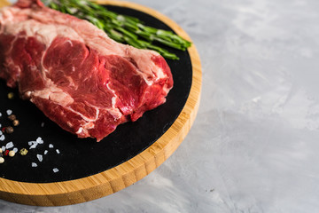Raw meat beef on a cutting board with rosemary and spices. Top view, flat lay, mockup, copy space. Food concept
