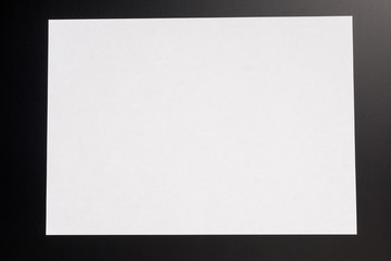 Blank white paper on black background  