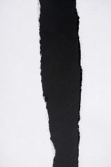 White torn sheet of paper on a black background  