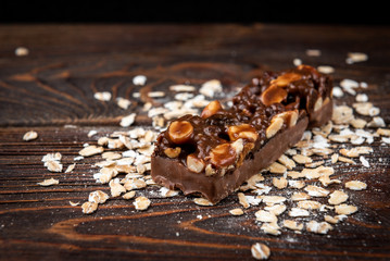 Granola bar with chocolate dark wooden background.