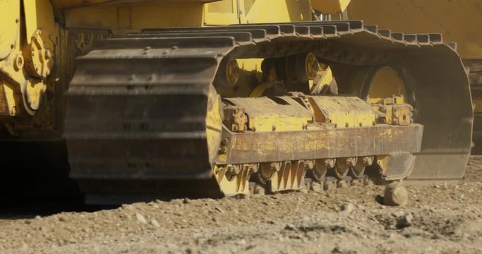 Close up of bulldozer tracks going backwards.