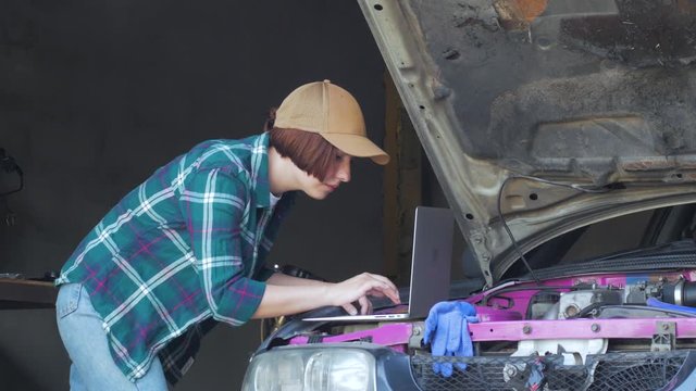 Female mechanic fixing car in a garage	