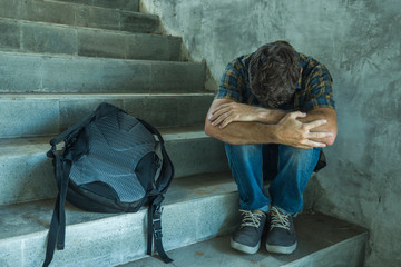 Campaign vs homophobia with young sad and depressed college student man sitting on staircase...