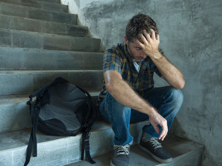 Campaign vs homophobia with young sad and depressed college student man sitting on staircase...