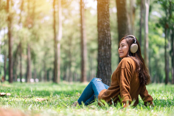 A beautiful asian woman enjoy listening to music with headphone with feeling happy and relaxed in...