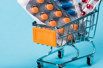 Pharmacy medicine concept. Shopping cart with pills and capsules