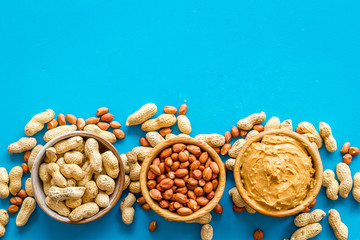 nuts in bowl for peanut butter for cooking breakfast at home on blue background top view mock-up