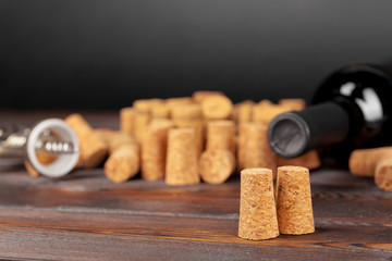 Wine corks with corkscrew on wooden table