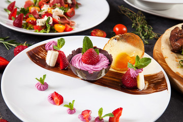 Close up view on tasty and cold strawberry ice cream in a chocolate bowl. Fresh dessert after lunch. Dark background. Food photo with sweets for menu or recipe