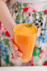 Woman holding bottle with delicious smoothie close up