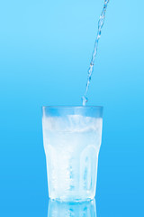 Close up pouring purified fresh drink water from the bottle on table