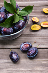 Closeup of plums on rustic wooden table.