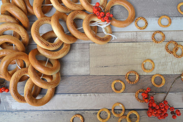 Drying wheat flour with rowan berries.  Frame of big and small bagels on wooden shabby table. Russian food.