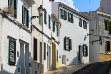 Fototapeta na wymiar Empty street with whitewashed houses in Alaior town, Alaior, Menorca, Spain