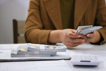 Businessman analyzing investment charts and pressing calculator buttons over documents. Accounting Concept.