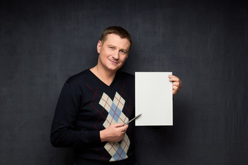 Portrait of cheerful man holding blank paper sheet
