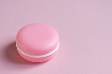 Cosmetic cream in the form of a macaroni cake on pink with place for text. Concept of beauty, makeup, femininity, fashion