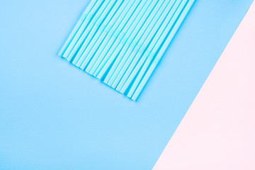 Blue cocktail straws on a two-toned background.