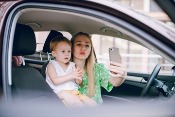 Mom puts her little son in a car seat and buckles him