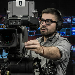 Young Glasses Cameraman Doing His Job in Television Studio