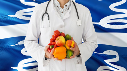 Doctor is holding fruits and vegetables in hands with Martinique flag background. National healthcare concept, medical theme.