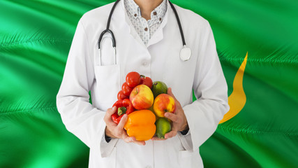 Doctor is holding fruits and vegetables in hands with Mauritania flag background. National healthcare concept, medical theme.