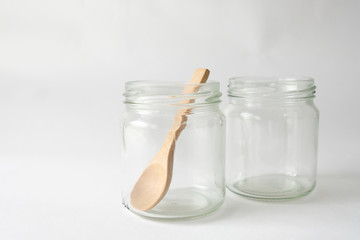 Two glass cups with a brown wooden spoon placed on a white background