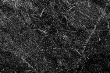 Fototapeta na wymiar Schlittschuhspuren auf schwarzer Eis Öberfläche
