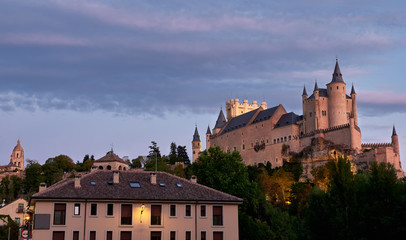 Fototapeta na wymiar Ciudad de Segovia, España, desde una de sus antiguas calles, donde se puede observar el alcazar y la catedral al atardecer