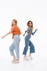 Obraz premium Full length photo of two positive girls wearing colorful clothes laughing and having fun together at camera