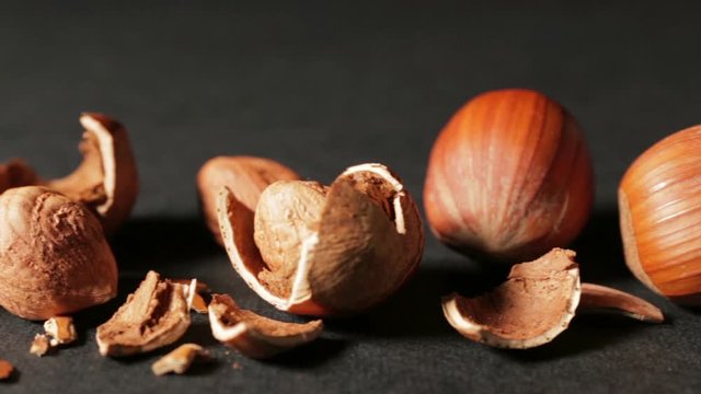 Tracking of some shelled hazelnuts with shell fragments around them, isolated on a black background