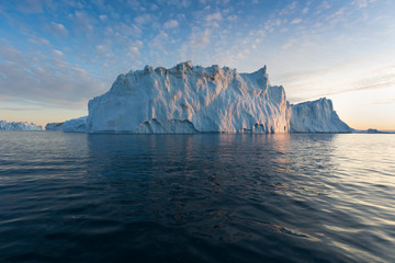 Naklejka na ściany i meble Nature and landscapes of Greenland or Antarctica. Travel on the ship among ices. Studying of a phenomenon of global warming Ices and icebergs of unusual forms and colors Beautiful midnight sun on ship