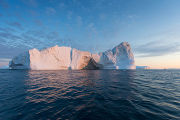 Obraz na płótnie Canvas Nature and landscapes of Greenland or Antarctica. Travel on the ship among ices. Studying of a phenomenon of global warming Ices and icebergs of unusual forms and colors Beautiful midnight sun on ship