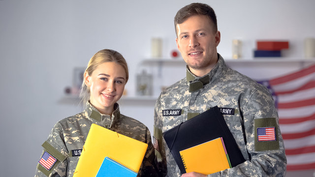 Female And Male US Military Students With Folders Smiling At Camera, Education