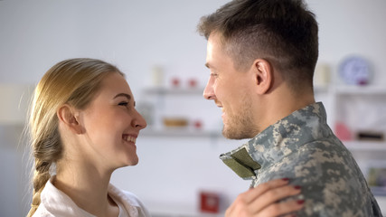 Cheerful wife looking with love at military boyfriend returning from army, love