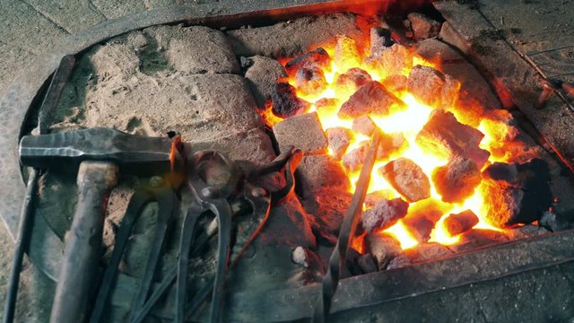 Forging tools lying near fire.