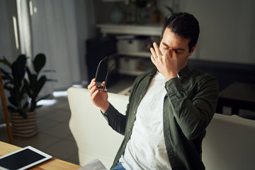 Man taking off glasses feels unhealthy suffering from eye strain