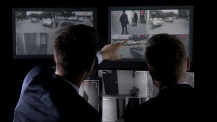 Private agents monitoring CCTV footage, searching for criminal, discussion - 285439784