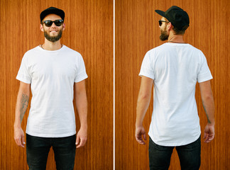 Hipster handsome male model with beard wearing white blank t-shirt and a baseball cap with space for your logo or design in casual urban style. Back and front view