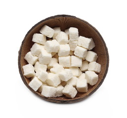 Coconut cubes, pieces, healthy sliced and diced snacks with shell isolated on white background