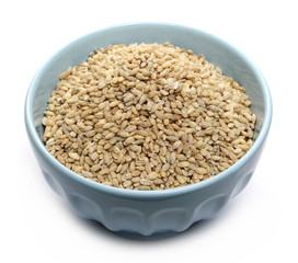 Peeled barley grains in bowl isolated on white background