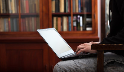 Student is working for exams in laptop in library