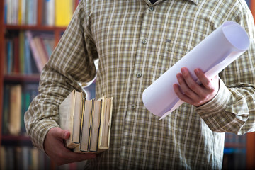 Student boy with books and plan in the library