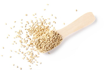 Organic integral sesame seeds with wooden spoon isolated on white background, top view