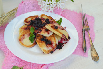 Sweet pancakes with jam and mint, white plate on pink napkin